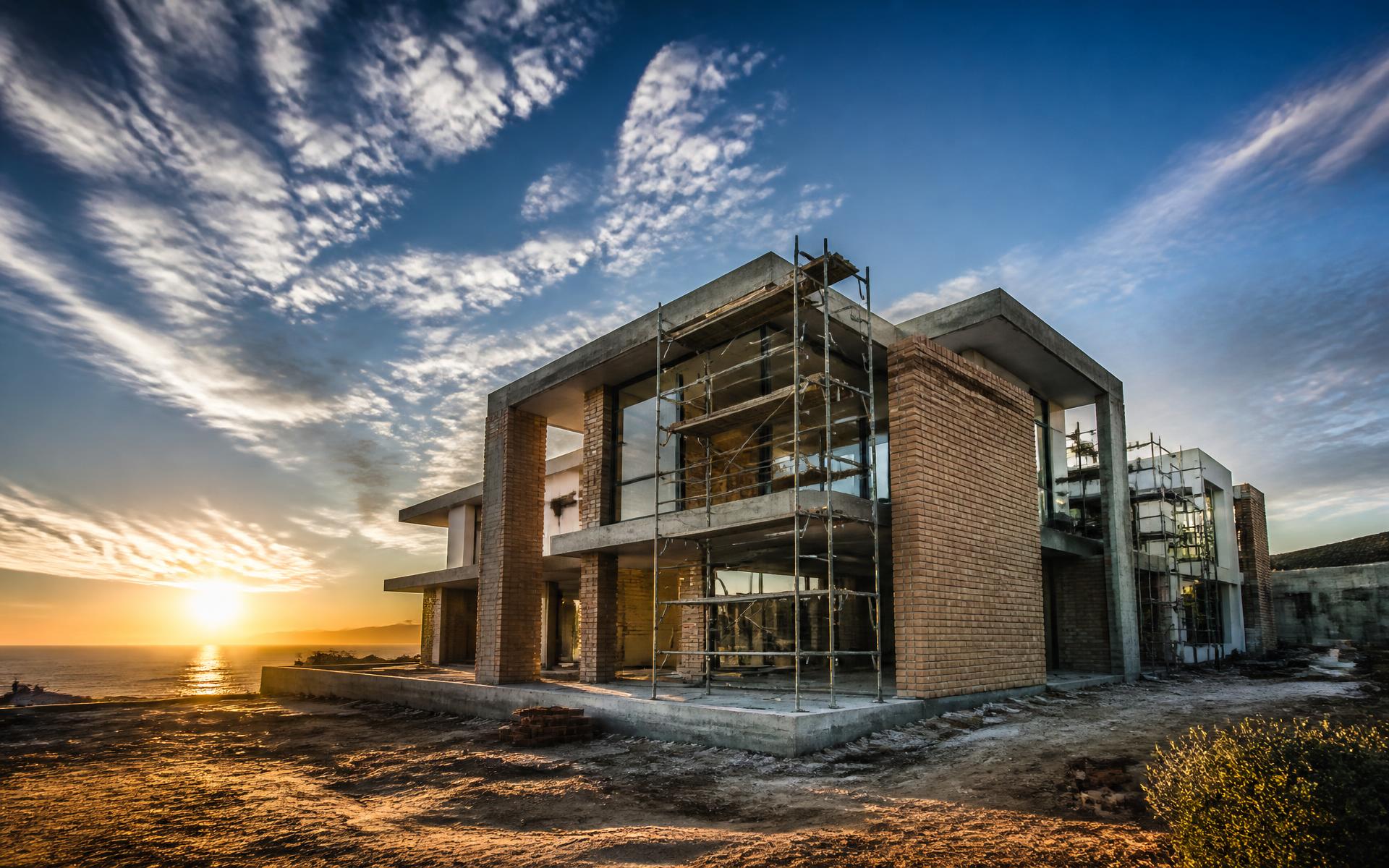 Coastal home under construction by P&G Construction at sunset